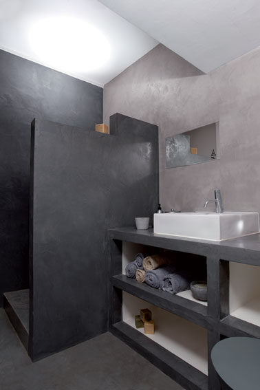 salle de bains réalisée en beton ciré pour les murs, la douche italienne ainsi que le plan de travail supportant une grande vasque blanche rectangulaire