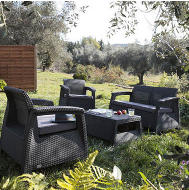 Salon de jardin en résine de couleur anthracite compsé d'une banquette de 2 fauteuils et d'une table basse