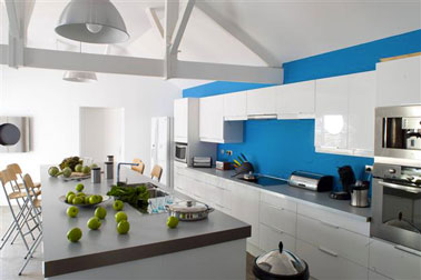 Cuisine avec îlot central en bleu et blanc. Peinture murale couleur bleu pacifique de la collection prestige de Julien. Plan de travail gris anthracite