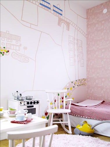 Dans cette chambre de petite fille, un des murs est décoré avec un grand dessin naïf réalisé à l'aide de feutre rose et de peinture acrylique