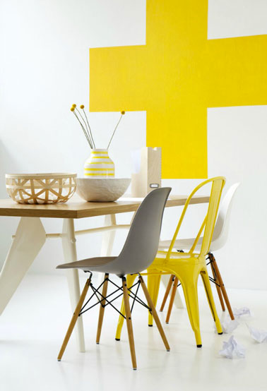 Salle à manger d'un petit appartement, table bois, chaise Tolix jaune, chaises coques blanc et taupe