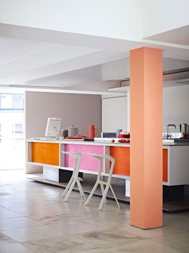 Une cuisine aux murs gris dynamisée par les carrés de peinture sur le devant des meubles de couleur orange et rose de la gamme Cuisine & Bain de Dulux Valentine 