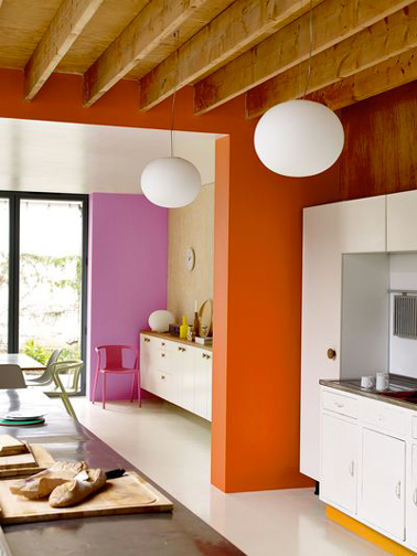 Des couleurs pour booster une cuisine blanche. Une idée astucieuse, les pans de murs entre la cuisine et la salle à manger sont peints l'un en rose l'autre en orange. Peinture couleur Orange Sanguine, Zeste d’orange et Girly Crème de couleur Dulux Valentine