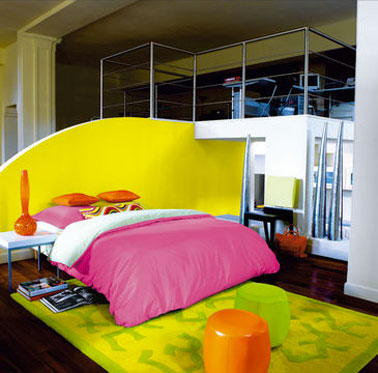 deco chambre couleur flashy. tete de lit peinture jaune fluo, tapis assorti. Couette et coussin rose flashy