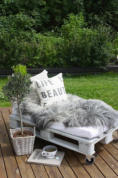 banquette jardin fabriquée avec palette bois peinte en blanc, pour le confort, un matelas fabriqué sur mesure et des coussins