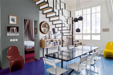 couleurs salle à manger pour une déco des années 60. Sol peint bleu vif, mur gris souris et blanc, fauteuil 60' rouge et jaune.
