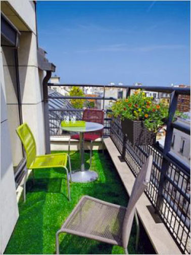 Un sol recouvert de gazon synthétique pour un petit balcon accueillant et joli comme tout décoré par du mobilier de jardin tressé couleur vert et taupe de chez Truffaut
