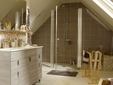 salle de bain italienne installée sous combles fermée avec paroi de verre. murs et sol carrelé, meuble sous vasque gris perle 