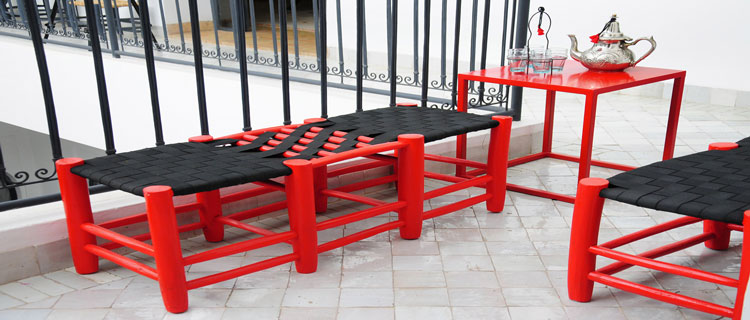 table, chaise, fauteuils et jardinière, le rouge et le noir s'associent pour une décoration chic de la terrasse et du balcon
