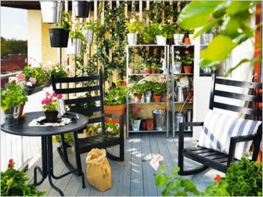 Une jolie façon d'aménager son balcon en ville avec de la verdure et du mobilier d'extérieur en bois noir. Un revêtement sol lame de terrasse en pin pour un joli balcon !