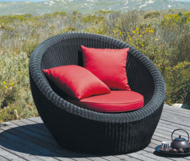 Pouf terrasse en résine tressée noir. Coussins rouge. Maison du Monde