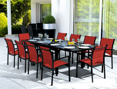 Salon de jardin avec table plateau coulissant permettant de doubler sa longueur. Chaises assorties assise rouge, cadre noir