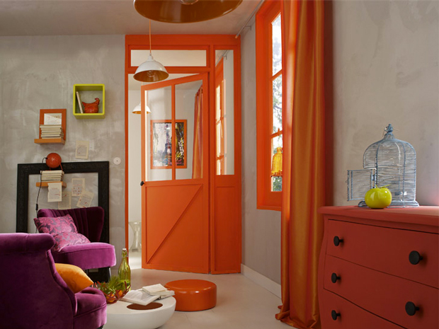 peinture salon grise et orange pour donner du peps à la déco et apporter de la lumière. Aux murs, un enduit effet béton gris pastel pour une ambiance style industriel associé à une peinture orange sur les boiseries et pour repeindre la commode en bois.