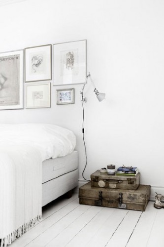 Pour la décoration de cette chambre blanche au design épuré, la tête de lit est réalisée avec une composition de dessins au fusain mis sous cadre de plusieurs dimensions pour donner plus de rythme à la composition.