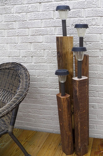 Des torches de jardin solaire plantées dans des poutres pour l'éclairage de la table de jardin, c'est pratique et design