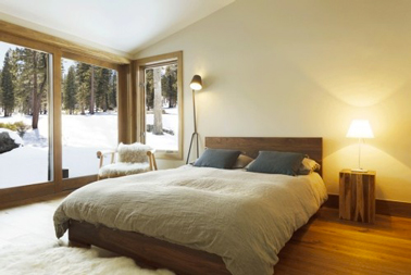 Déco chambre couleur taupe et lin pour une ambiance scandinave. Peinture murale couleur lin clair, tête de lit couleur taupe, linge de lit en lin naturel, un grand tapis en laine et à longues mèches pour renforcer l'impression de confort