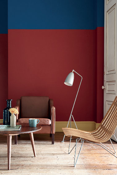 Les couleurs intenses peuvent être introduites dans un salon à condition de ruser avec les teintes claires pour illuminer la pièce. Un bon exemple ici, où le rouge et bleu chics et chaleureux du mur qui structure l'espace