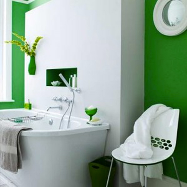 salle de bain verte et blanche pour une ambiance naturelle et design. Ici, c'est le vert émeraude qui est mis à l'honneur sur les murs. La chaise et les accessoires de salle de bains reprennent le vert émeraude de la peinture pour un bel équilibre des valeurs