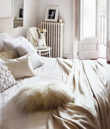 Décoration chambre adulte beige et blanche pour une ambiance cocooning et féminine. Mélange de matières soyeuses et fourrures pour les coussins et le linge de lit en nuances de beige et blanc.