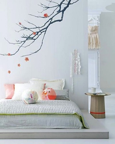 Chambre blanche et gris ambiance zen. Peinture gris perle, plafond et armoire ancienne peints en blanc pur. Le matelas est posé sur une estrade réalisée en bois et peinte en gris plus soutenu. Touches de vert tendre et rose pour Coussins et couvre-lit