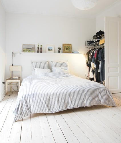 Décoration chambre adulte avec murs, parquet et tête de lit blanc. Housse de couette coton à rayures grises et blanches complète l'harmonie de couleurs déco.