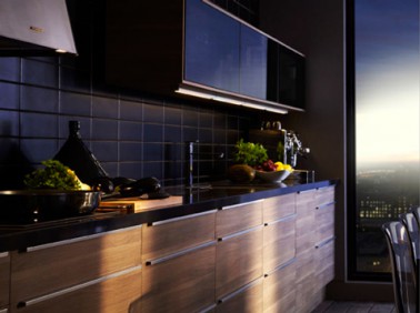 Déco cuisine noire avec une crédence en carrelage style métro noir satin. Meubles haut portes coulissantes et plan de travail noir brillant. Façades meubles bas en noyer couleur gris clair. Modèle Sofielund chez Ikéa 