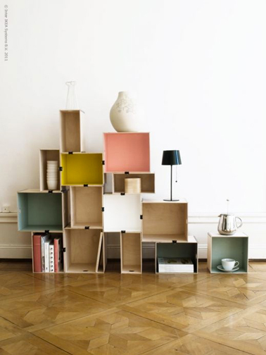 Une idée de bibliothèque à fabriquer soi-même avec des caisses en bois de récup et peintes dans des couleurs en harmonie avec le salon. Fixer les caisses entre elles avec des pinces à dessin