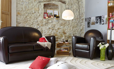 Déco salon esprit club avec canapé convertible en cuir noir, fauteuil assorti