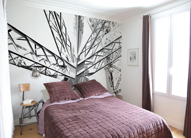 Pour agrandir une petite chambre lorsque l'on veut poser du papier peint, il est conseillé de le poser sur le mur qui accueille la tête de lit et le choisir avec des grandes lignes de préférence 
