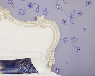 Déco chambre violet avec une  de ses nuances claires pour la peinture murale parme de Dulux Valentine et des fleurs violet plus soutenu en décoration murale autour de la tête de lit blanc ivoire