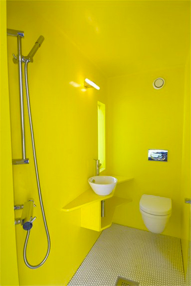 Déco WC design avec autour de la cuvette wc suspendu et du lave main blanc une peinture jaune citron sur les murs et le plafond