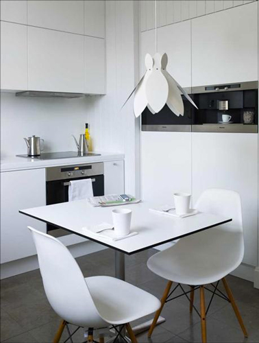Une petite cuisine qui adore le blanc pour donner l'impression d'un espace plus grand En plus d'être très sobre, la couleur blanche a également la capacité de donner l'illusion d'une pièce plus grande et lumineuse ! C’est notamment pour cela que les cuisines exiguës s’entichent de cette teinte sobre et pure comme dans ce petit coin repas où la blancheur des meubles permet à la fois d’épurer l’espace et de le rendre d’apparence plus spacieux. Quelques accessoires électroménagers en inox associés avec le mobilier central style old school simple et vous obtenez une cuisine moderne accueillante.