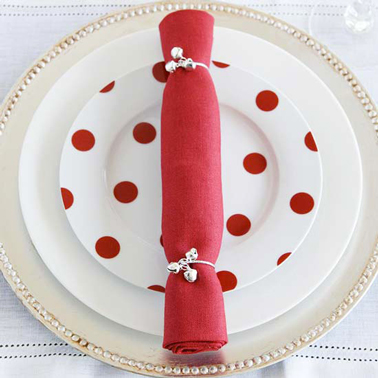 Un pliage de serviette ultra simple à faire et qui fera son effet sur une assiette rouge et blanche ! La serviette rouge est pliée en rouleau et fermée par deux cordons argenté 