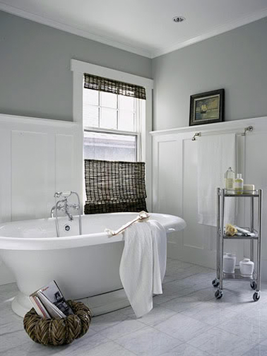 Une grande salle de bain grise aménagée pour se reposer en toute tranquillité dans laquelle tout se décline en gris et blanc et quelques touches de noir avec le store et le cadre photo