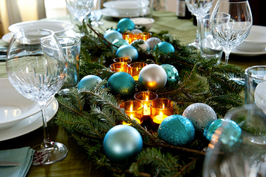 Centre de table de Noël composé de branche de sapin, de boules de Noël bleu turquoise brillantes et mates