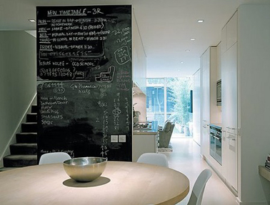 Espace cuisine salle à manger conçu par le cabinet d'architecture Alan Higgs Architects avec une cloison de séparation peinte avec peinture à tableau noir