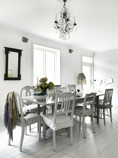 Salle à manger en total look gris pastel du sol au plafond. La table et les chaises dépareillées sont peintes en gris perle.