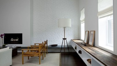 Magnifique salon design ou le bois des quelques meubles et du parquet wengé créent une ambiance cocooning autour des murs d'un blanc immaculé.
