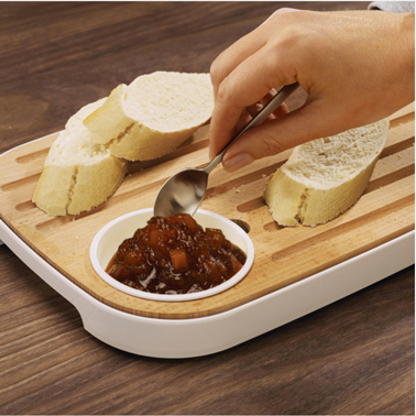 Planche à pain en hêtre dans plateau de mélaminé et petit plus bien pratique coupelle intégrée dans la planche pour contenir confiture ou sauce de chez JosephJoseph.
