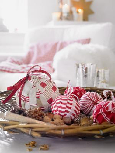 Pour un Noël en rouge et blanc récupérer les boules de l'an dernier et enrouler des bandes de tissu rouge et blanc, à compléter d'un ruban rouge pour les accrocher dans le sapin