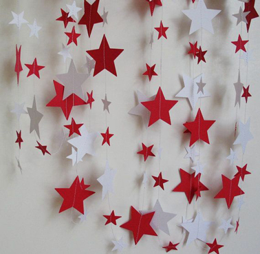 Un rideau d'étoiles en papier Canson rouges et blanches montées sur fil de nylon à accrocher sur le mur pour une décoration de Noël fait maison