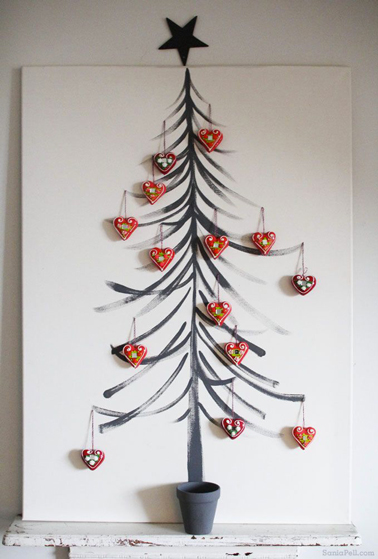 Sapin de Noël peint sur un chassis toilé blanc, le pied est symbolisé par un pot peint en vert, décoration rouge