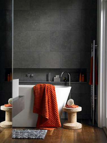 decoration design pour une salle de bain noir et blanche avec un carrealge mural gris anthracite et sa baignoire ilot blanche. le tout sur un superbe parquet chêne vitrifié