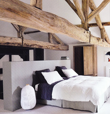 Aménagement d'une chambre grise sous les combles avec une cloison centrale qui sert de tête et de séparation avec la salle de bain
