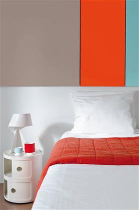 Déco chambre contemporaine : Sur le mur derrière tête de lit 3 bandes de peinture en contraste : une couleur orange intense équilibrée par une bande de gris neutre et un vert froid. Le plaid orange qui drape le lit introduit un autre source de couleur lumineuse.