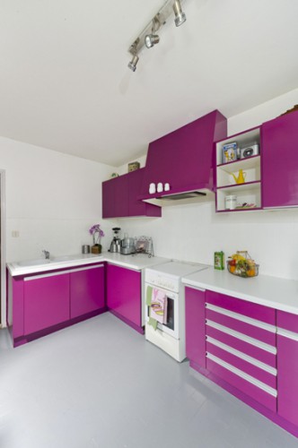 Pour repeindre un meuble en bois avec la peinture pour meuble de cuisine GripActiv V33 sans poncer dans cette cuisine, 2 couches de peinture couleur violet (Papillon) sur les meubles haut et bas et couleur blanc sur la crédence en carrelage. Photo après