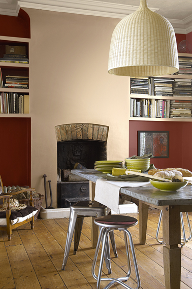 peinture mur salon couleur rouge et cheminée peinte beige rosé Dans le salon, Une peinture d'un rouge généreux sublime le mur de la cheminée peint en beige rosé. Photo Astral