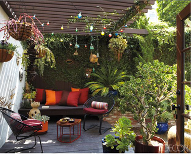 Des couleurs chaudes pour une terrasse intime sous auvent en bois