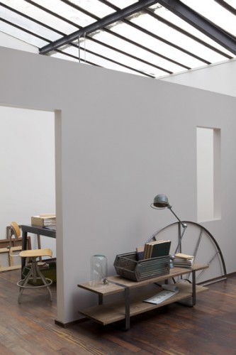 Une peinture salon de couleur grise en finition mate permet d'atténuer la lumière en provenance du toit verrière qui baigne le salon. Pour une déco salon esprit loft et chaleureuse, la peinture grise est associée à un sol parquet bois. Couleur peinture : Collection inspiration industrielle, Univers Loft Chic chez Guittet.