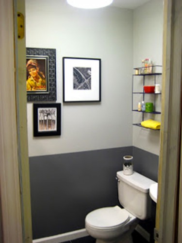 Peinture WC de deux couleurs : gris anthracite pour peindre le soubassement et gris perle sur le haut des murs. Cuvette WC et lave-mains blanc. Etagères en fer pour le rangement des accessoires